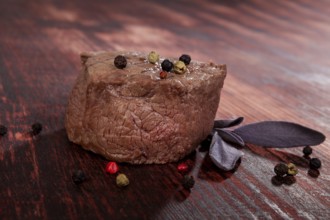 Luxurious sirloin steak on wooden background with peppercorn and herbs. Culinary red meat eating.