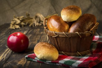 Baked apple pies in basket on wooden table