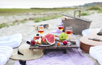 Picnic on the beach at sunset in the style of boho. Food and drink, relax, holiday concept