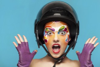 Portrait of a beautiful young model with bright creative make up with helmet