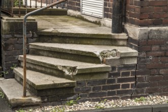 Dilapidated small stone staircase on house wall