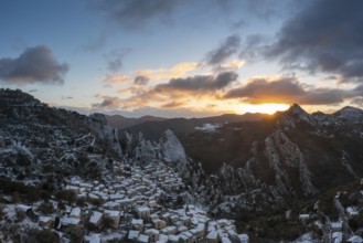 A drone view of Castelmezzano at sunrise in winter