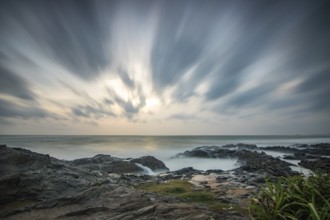 Beach, with lava rocks and vegetation, view of the sea in the evening at sunset. Landscape with
