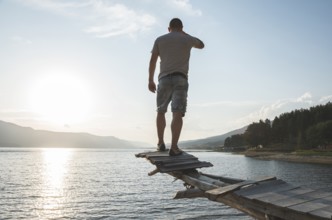 Young adult in front of mountain dam