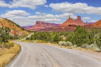 The reds and browns of Utah's vibrant landscapes. Wide asphalt highway among picturesque hills and