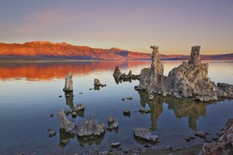 The magic of Mono Lake. Outliers -calcareous tufa formation on the smooth water of the lake. Orange