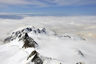 Cloud gathers around the alpine peaks of the Southern Alps, Westland, New Zealand