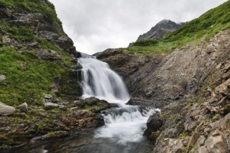 Summer mountain landscape of Kamchatka: beautiful view of picturesque waterfall in Mountain Range