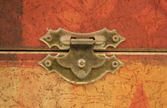 An old tarnished clasp fastening a lid to a box