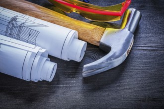 Rolls of blueprints hammer goggles