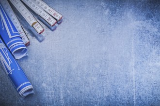 Blue blueprints wooden meter on metallic background copyspace construction concept