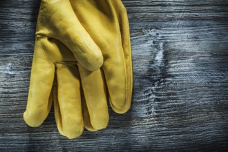 Pair of protective gloves on wooden board