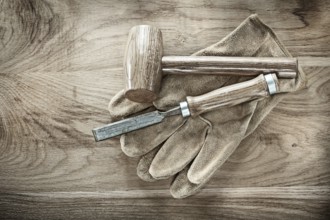 Wooden hammer chisel protective gloves on wood board
