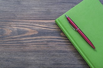 Notepad brio pen on wooden board office concept