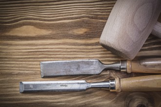 Wooden mallet chisels on vintage wood board construction concept