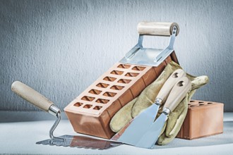 Trowels brick and gloves on concrette background