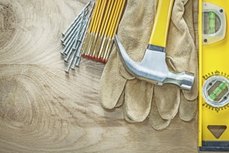 Construction level leather safety gloves wooden meter claw hammer nails on wood board building