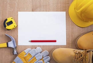 Pencil paper helmet boots gloves hammer tapeline on wooden board organized copyspace
