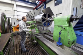 An older worker in the metal industry at a CNC milling machine, Austria