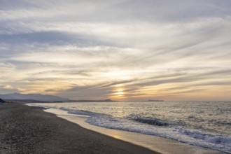Beautiful coastline with a sandy beach and pebble beach at sunset. Beautiful sky colouring in the