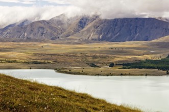 Lake Tekapo and the surrounding hills under clouds, South Island, New Zealand