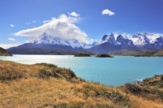 The strong wind drives turquoise waves on the lake, grandiose rocks Los Kuernos are covered with