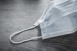 Sterile medical face mask on vintage wooden board
