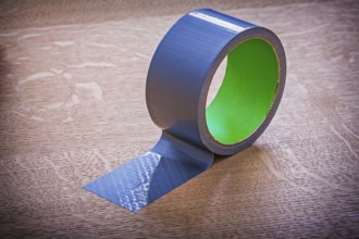 Unwound duct tape on vintage wooden board maintenance concept