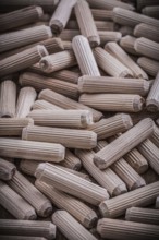Collection of woodworking dowels on wooden board construction concept