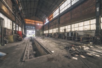 Dark, abandoned industrial hall with metal structures and rubbish on the floor, HF4 steelworks,