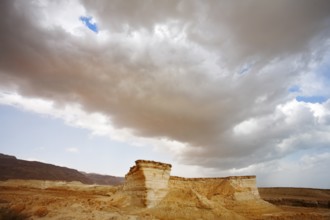 Huge cloud of the freakish form above stone desert. Spring in Israel