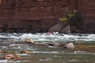 Sporting young woman in a kayak overcame stormy over the Colorado River