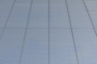 Closeup of metal mesh on concrete wall background texture