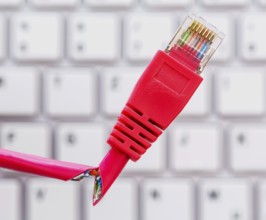 Defective network cable on keyboard, symbolic photo for online, networks, interference and