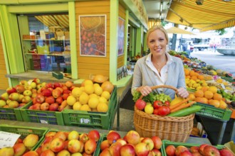 A young woman buys fruit and vegetables at a weekly market market. Fresh and healthy food. Austria