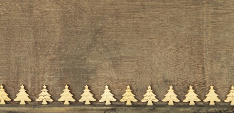 Christmas decoration wooden background with row of small wooden fir trees