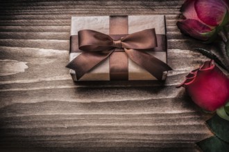 Red natural roses present box on wooden board holidays concept