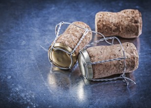 Alcohol cork plugs with twisted wires on metallic background