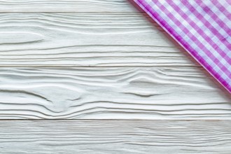 Pink checked towel on wooden board copy space