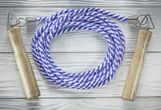 Rolled skipping rope on wooden board sports training concept
