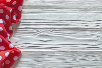 Red folded polka-dot table cloth on wooden board