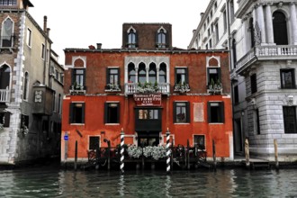 Venice, Veneto, Italy, Europe, Red building with white window frames on a canal in Venice