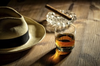 A glass of rum, a cigar and a Panama hat in a bar in Cuba