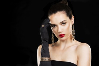Beautiful woman with dark makeup and red lipstick posing on black background, Toronto, Canada