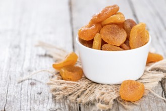 Small portion of dried Apricots (on wooden background)