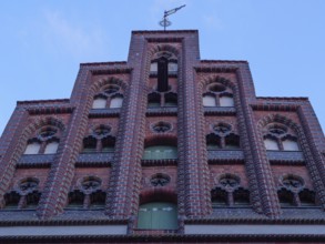 Close-up of a historic brick façade with window decorations and blue window, lüneburg, germany