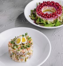 Food, Vibrant salad ring with pomegranate and traditional olivier salad on a festive table setting