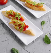 Food, Two plates of italian bruschetta with fresh tomatoes and arugula, ready to serve