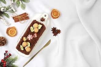 Homemade winter dessert, stollen or strudel with sweet cream filling, nuts, cinnamon and poppy