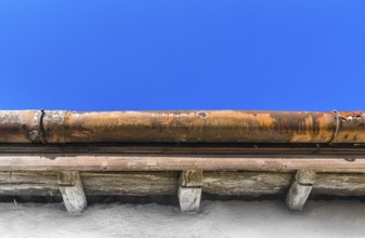 A broken gutter on the roof of a house